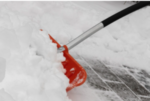 A red snow shovel pushing snow.